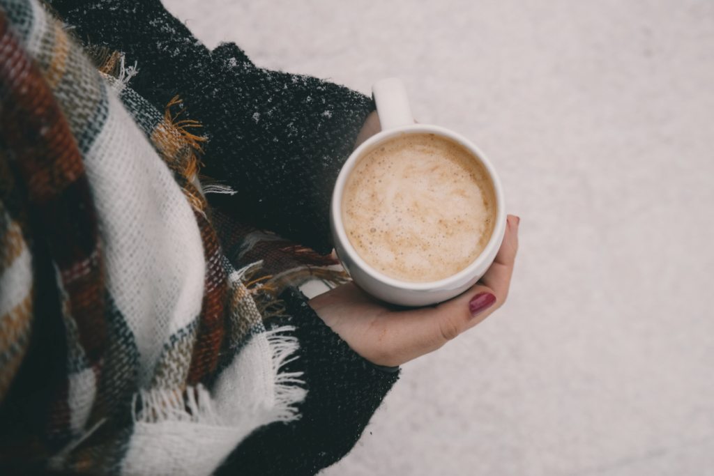 des mains adultes tiennent une tasse de chocolat chaud