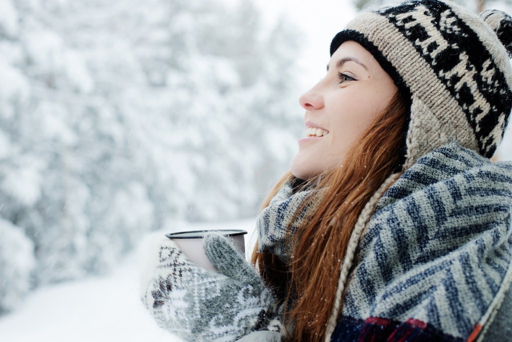 une jeune femme porte un bonnet dans la neige