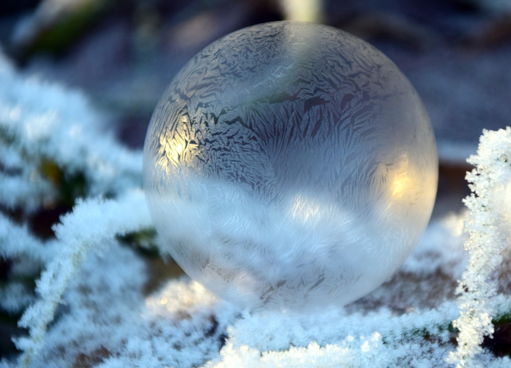 Une boule de neige décorative placée dans la neige en pleine nature 