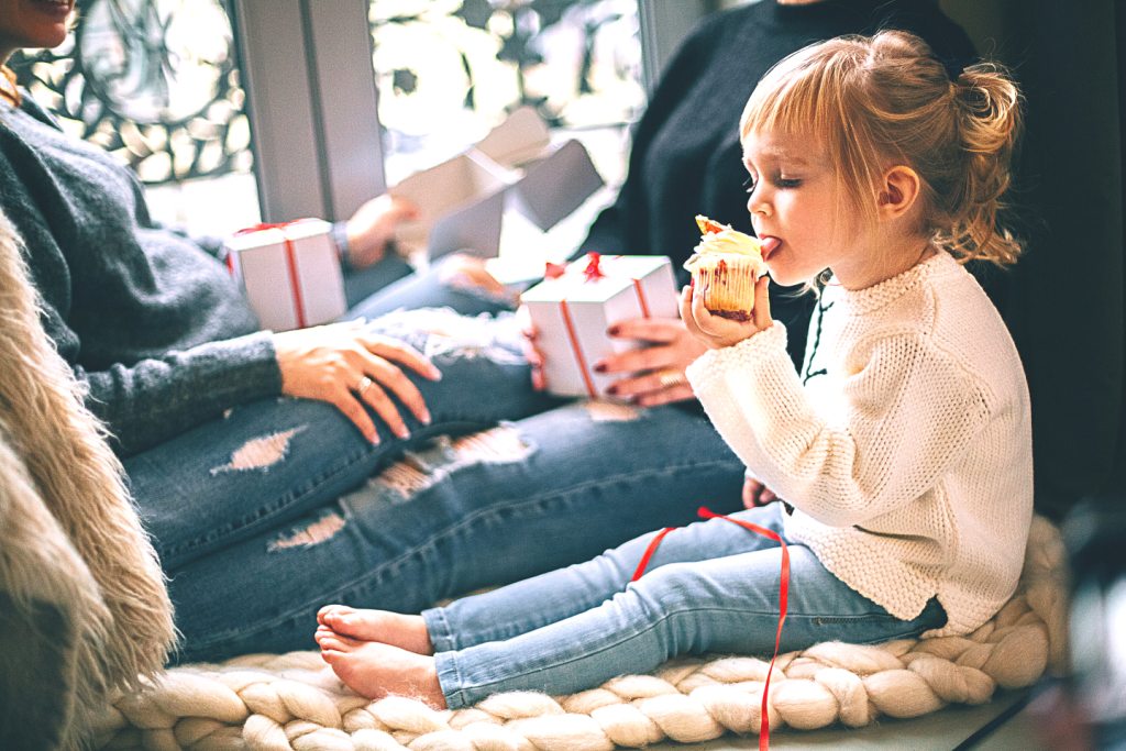 une fillette qui mange un cupcake