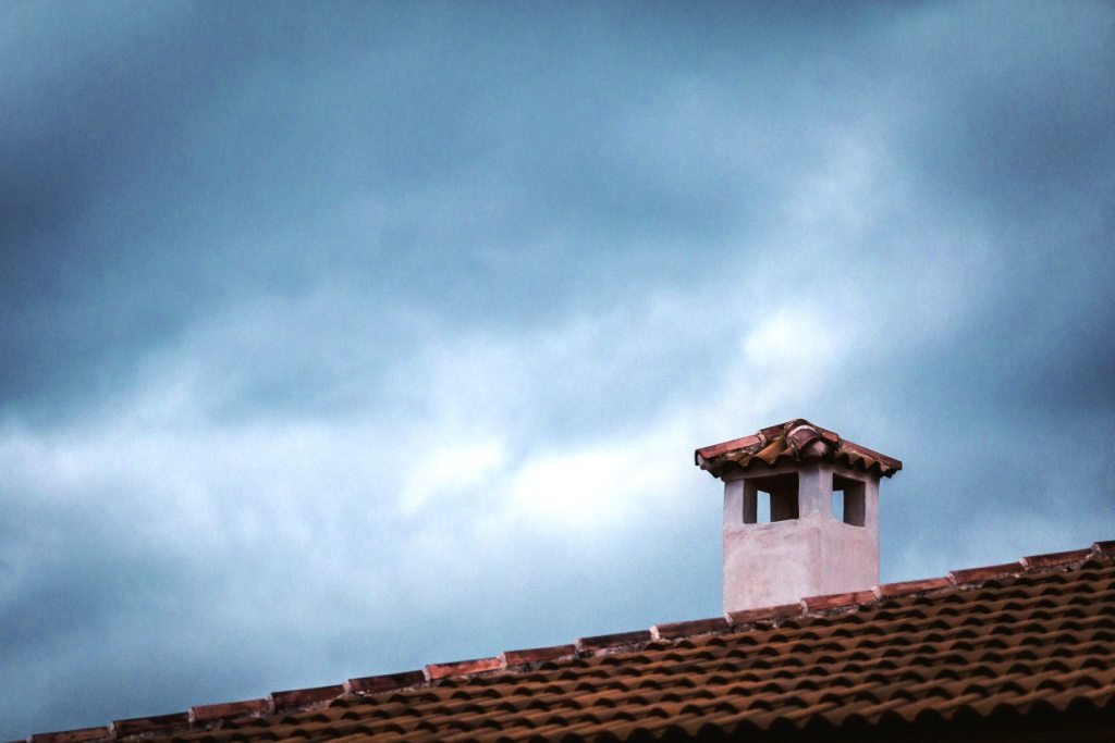 un toit avec cheminée sous un ciel gris