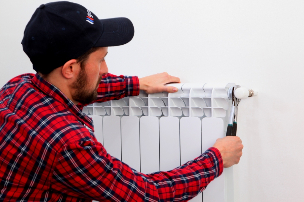 un chauffagiste fait un remplacement de radiateur